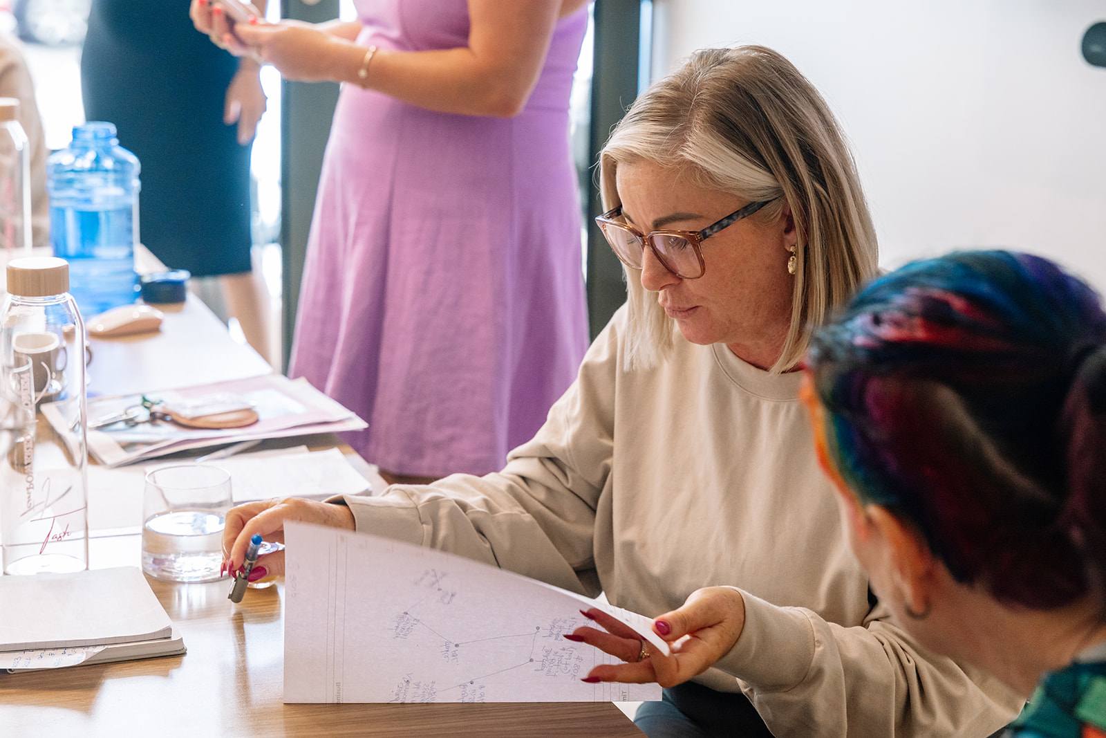 Women working through a large strategy sheet together at a FemPowered Intensive